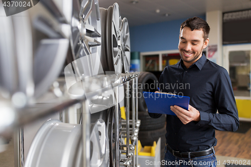 Image of auto business owner and wheel rims at car service