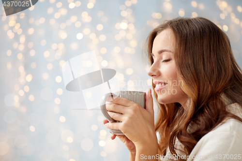 Image of happy woman with cup of tea or coffee at home