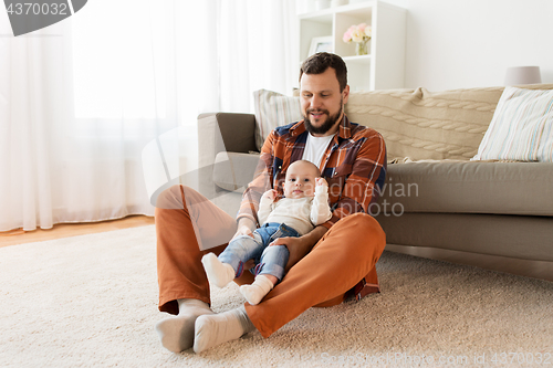 Image of happy father with little baby boy at home