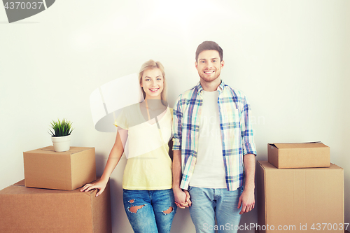 Image of smiling couple with big boxes moving to new home