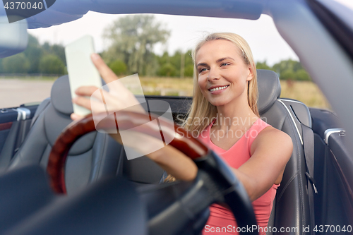 Image of woman in convertible car taking selfie