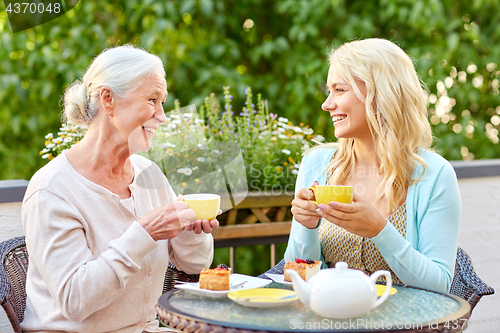 Image of daughter with senior mother drinking tea at cafe