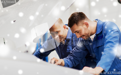 Image of mechanic men with wrench repairing car at workshop