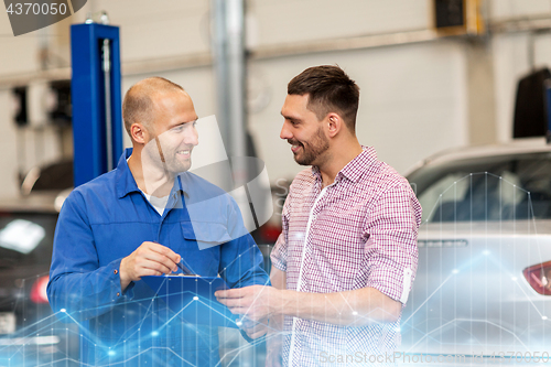 Image of auto mechanic with clipboard and man at car shop