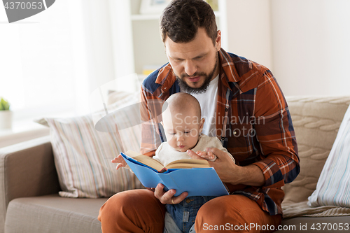 Image of happy father and little baby boy with book at home