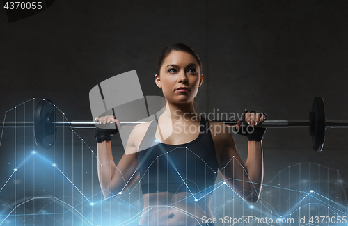 Image of young woman flexing muscles with barbell in gym