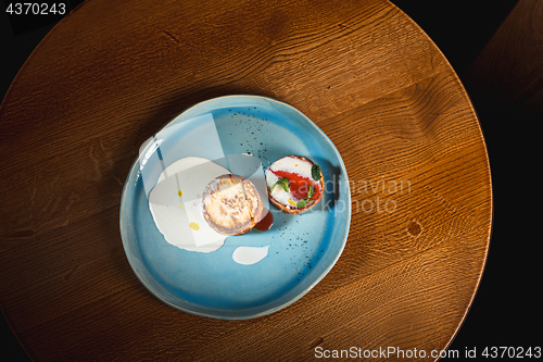 Image of plate with tasty pancakes on wooden table