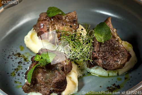 Image of Grilled steak with vegetables puree on plate.