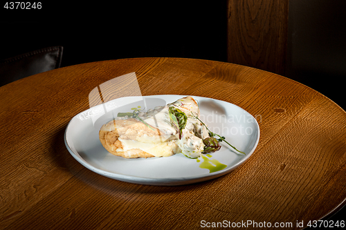 Image of closeup of a plate with a typical tortilla de patatas, spanish omelet, on a set table