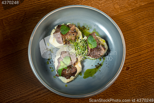 Image of Grilled steak with vegetables puree on plate.