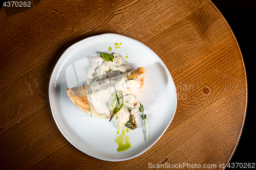 Image of closeup of a plate with a typical tortilla de patatas, spanish omelet, on a set table