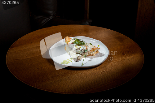 Image of closeup of a plate with a typical tortilla de patatas, spanish omelet, on a set table