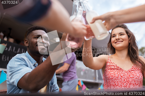 Image of friends clinking bottles with drinks at food truck