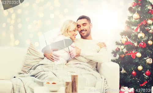 Image of happy couple hugging over christmas tree