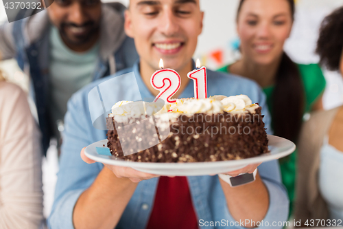 Image of man with cake and friends at birthday party