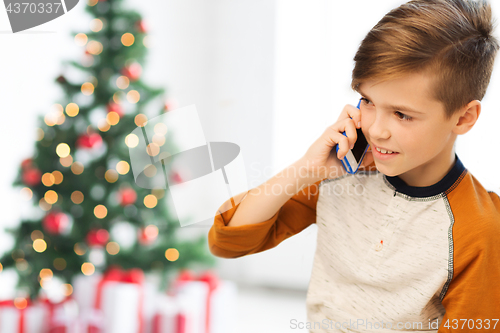 Image of boy calling on smartphone at home at christmas