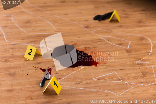 Image of chalk outline and knife in blood at crime scene