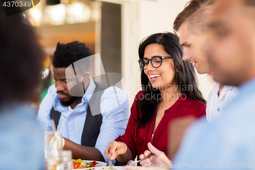 Image of happy friends eating at restaurant