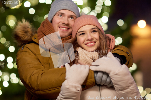 Image of happy couple hugging at christmas tree