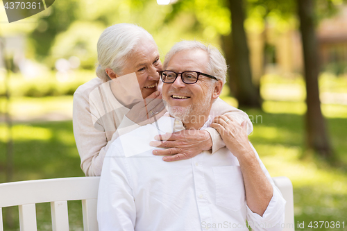 Image of happy senior couple sitting on bench at park