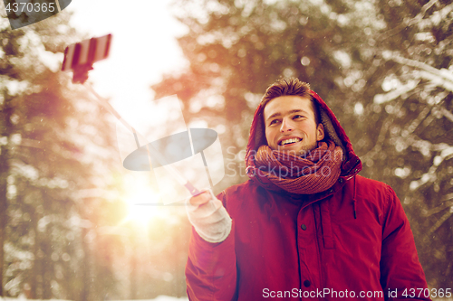 Image of happy man taking selfie by smartphone in winter