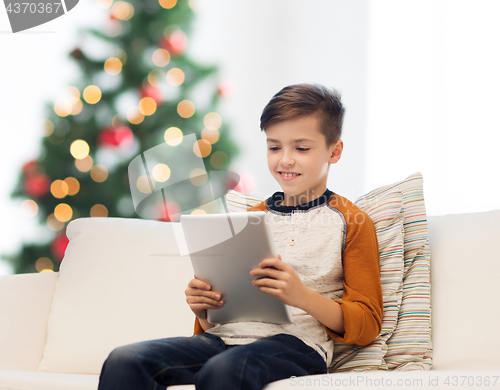 Image of smiling boy with tablet pc at home at christmas