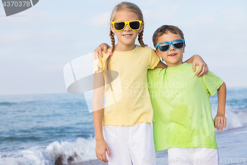 Image of Two happy children playing on the beach at the day time