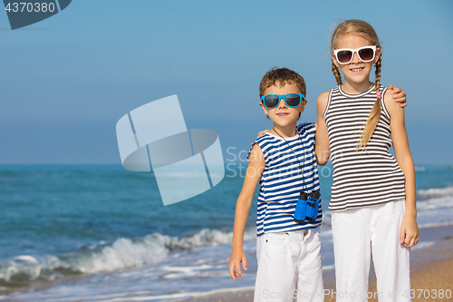 Image of Two happy children playing on the beach at the day time