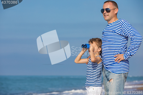 Image of Father and son playing on the beach at the day time. Concept of 