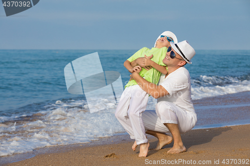 Image of Father and son playing on the beach at the day time. Concept of 