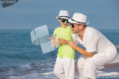 Image of Father and son playing on the beach at the day time. Concept of 