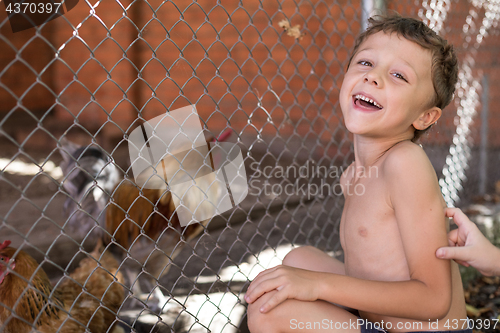 Image of Little boy with farm chickens