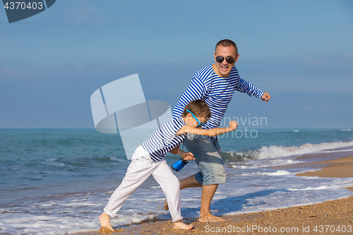 Image of Father and son playing on the beach at the day time. Concept of 