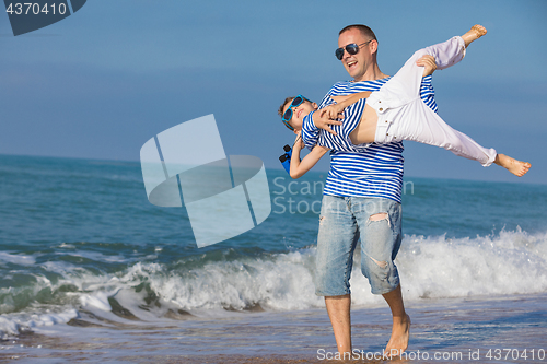 Image of Father and son playing on the beach at the day time. Concept of 