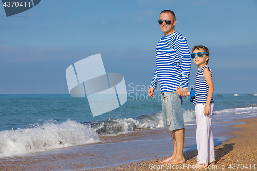 Image of Father and son playing on the beach at the day time. Concept of 