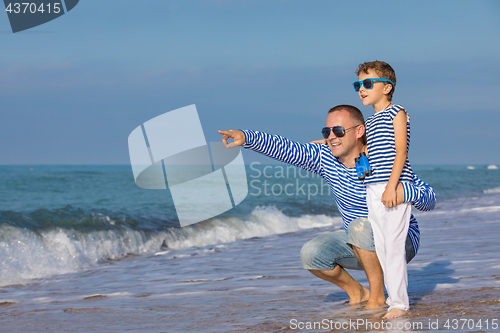 Image of Father and son playing on the beach at the day time. Concept of 