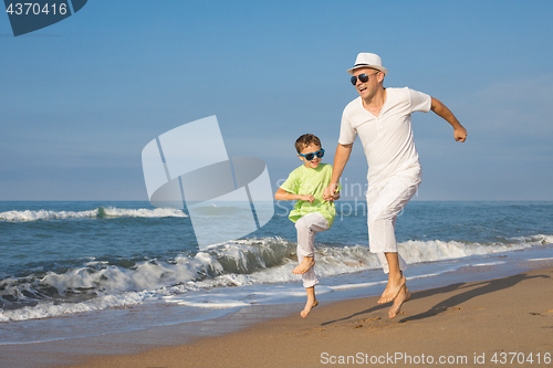 Image of Father and son playing on the beach at the day time. Concept of 