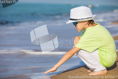 Image of One happy little boy playing on the beach at the day time