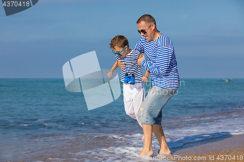 Image of Father and son playing on the beach at the day time. Concept of 