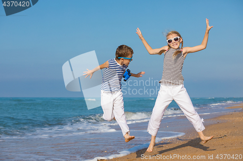 Image of Two happy children playing on the beach at the day time