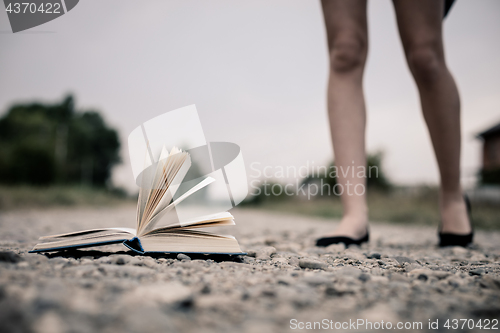 Image of open book lying on the road. 