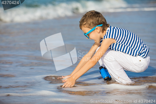 Image of One happy little boy playing on the beach at the day time