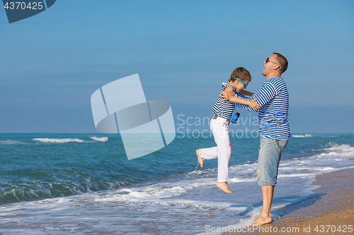 Image of Father and son playing on the beach at the day time. Concept of 