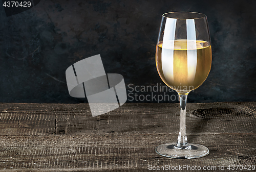 Image of Glass of white wine on a wooden table