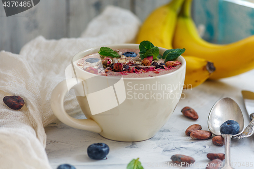 Image of Smoothie bowl with chocolate, cocoa beans and blueberries.