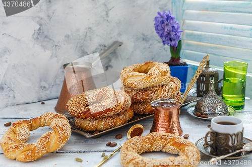 Image of Tasty bagels with sesame seeds and pots of coffee.