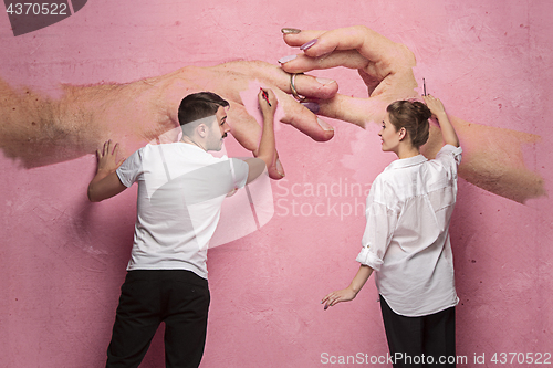 Image of The collage about couple writing something on a pink wall