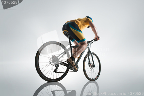 Image of The bicyclist on gray, studio shot.