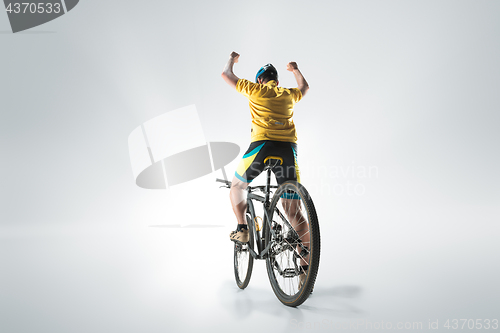 Image of The bicyclist on gray, studio shot.