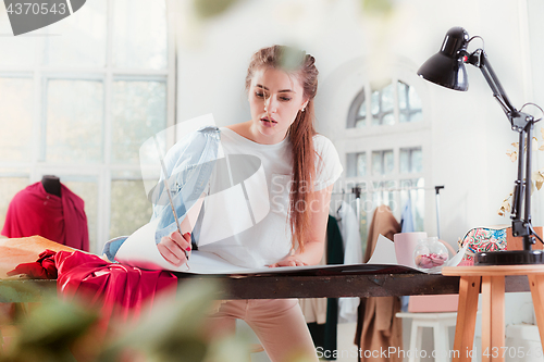 Image of Fashion designers working in studio sitting on the desk